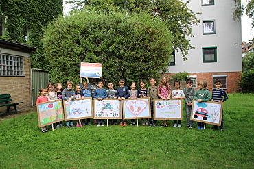 Die Klasse 3c mit Plakaten zum Thema zu Fuß zur Schule.
