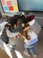 SchülerInnen welche einen Teamkreis machen bei den Juniorwahlen Kids.
